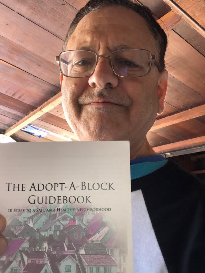 A man holding The Adopt-A-Block Guidebook